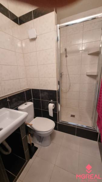 Koupelna s umyvadlem, toaletou a sprchovým koutem v 1-pokojovém bytě.