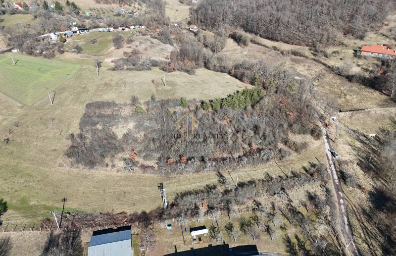 Letecký pohled na rozlehlé pozemky k bydlení v Krupině, s lesy a poli.