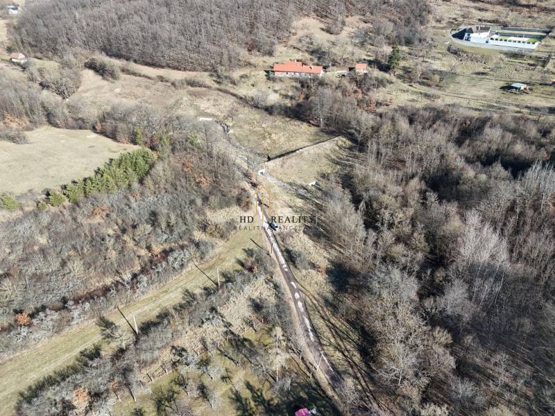 Pozemky - bydlení v Krupině blízko lesa s venkovskou krajinou a travnatými plochami.