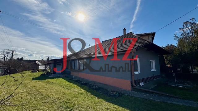 Rodinný dům v Mýtných Ludanoch s travnatou zahradou a cihlovou fasádou.