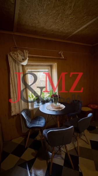 Jídelní kout v rodinném domě s podlahou se vzorem a židlemi kolem kulatého stolu.