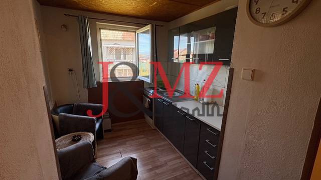 Kuchyně s podlahou s dřevěným dekorem a tmavými skříněmi v rodinném domě.