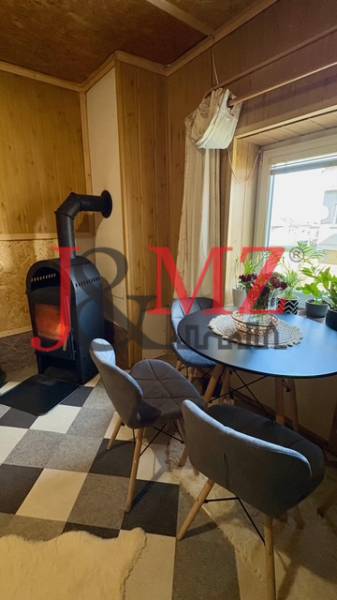 Krb v obývacím pokoji rodinného domu s kulatým stolem a dvěma židlemi.