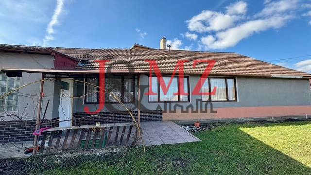 Rodinný dům v Mýtnych Ludanoch s dvorem, terasou a šedou fasádou.