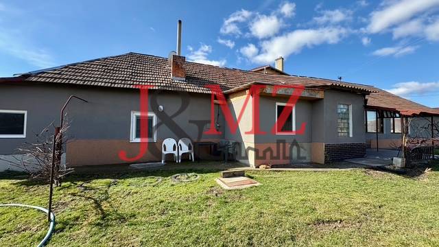 Rodinný dům v Mýtných Ludanoch s prostornou zahradou pod jasně modrou oblohou.