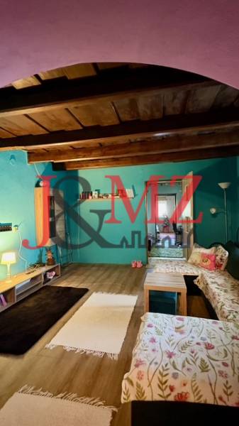 Pokoj v rodinném domě s podlahou s dřevěným dekorem a pohodlnými pohovkami.