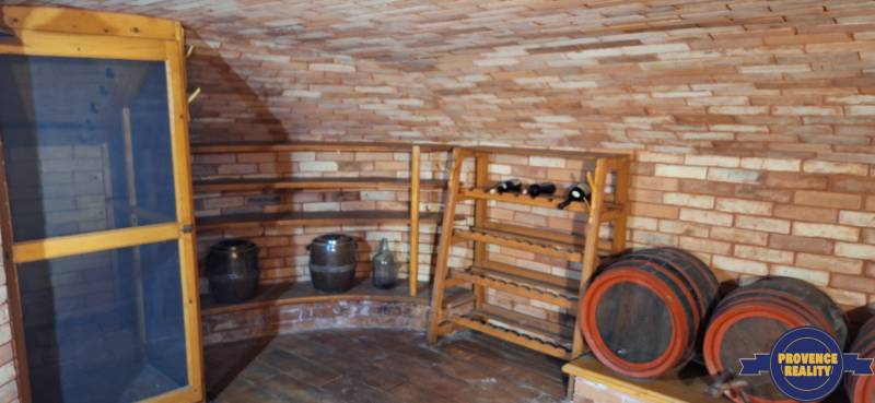 Vinný sklep s cihlovými stěnami a sudy v rodinném domě.