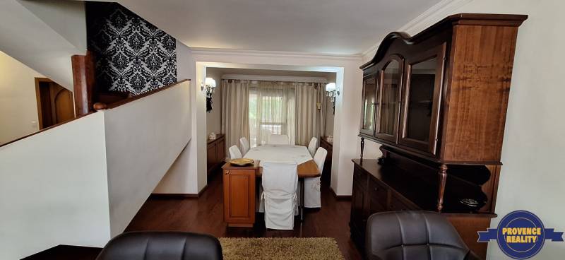 Jídelna s dřevěným nábytkem a podlahou s dřevěným dekorem v rodinném domě.