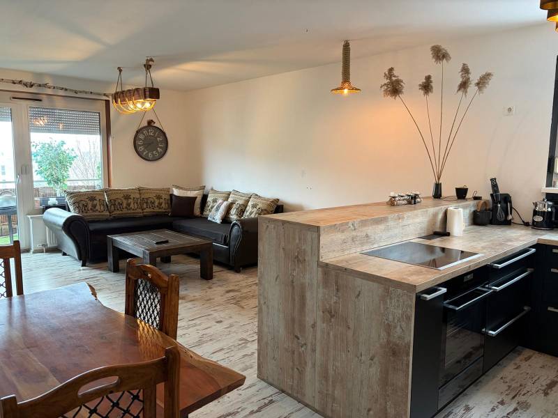 Kuchyně s jídelnou v 3-pokojovém bytě, podlaha s dřevěným dekorem, komfortní sedačka.