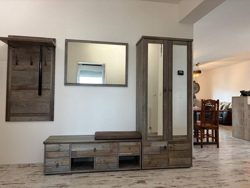 Chodba v 3-pokojovém bytě s věšákem a skříní, podlaha s dřevěným dekorem.