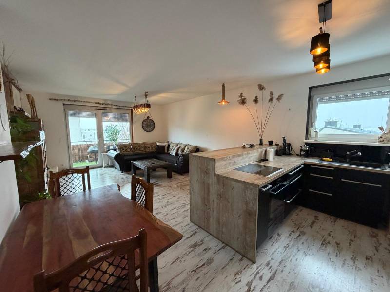 Obývací pokoj s kuchyní ve 3pokojovém bytě, podlaha s dřevěným dekorem.