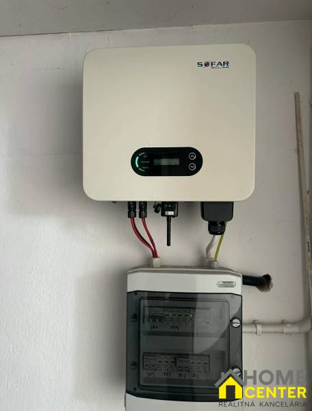 Solární invertor značky SOFAR namontovaný na stěně v rodinném domě.