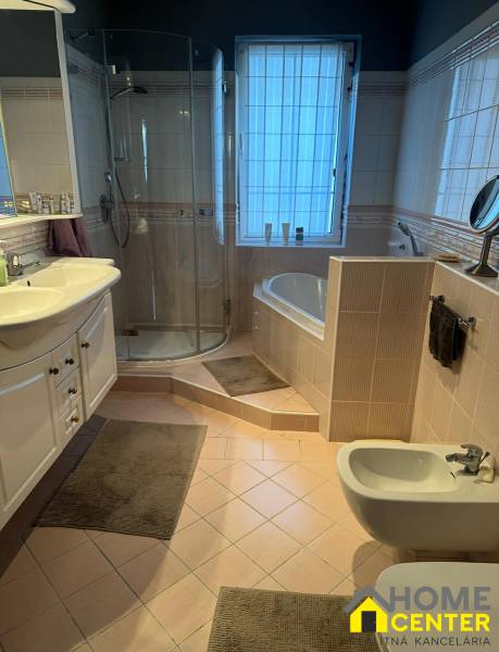 Koupelna v rodinném domě s vanou, sprchovým koutem, umyvadlem a bidetem.