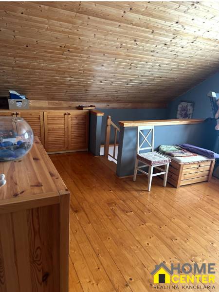 Podkroví rodinného domu s dřevěným stropem, stěnami a podlahou s dřevěným dekorem.