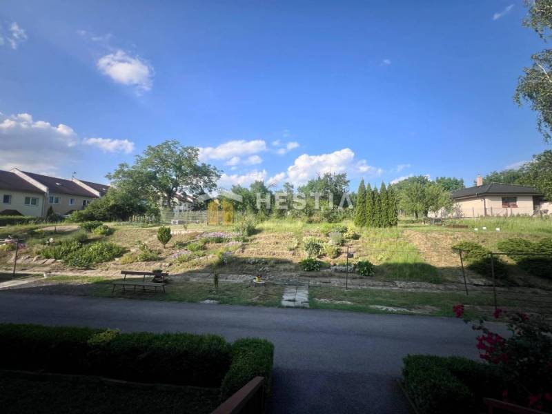 Pokojná zahrada s lavičkou a zelení u 3pokojového bytu v Moravském Lieskovém.