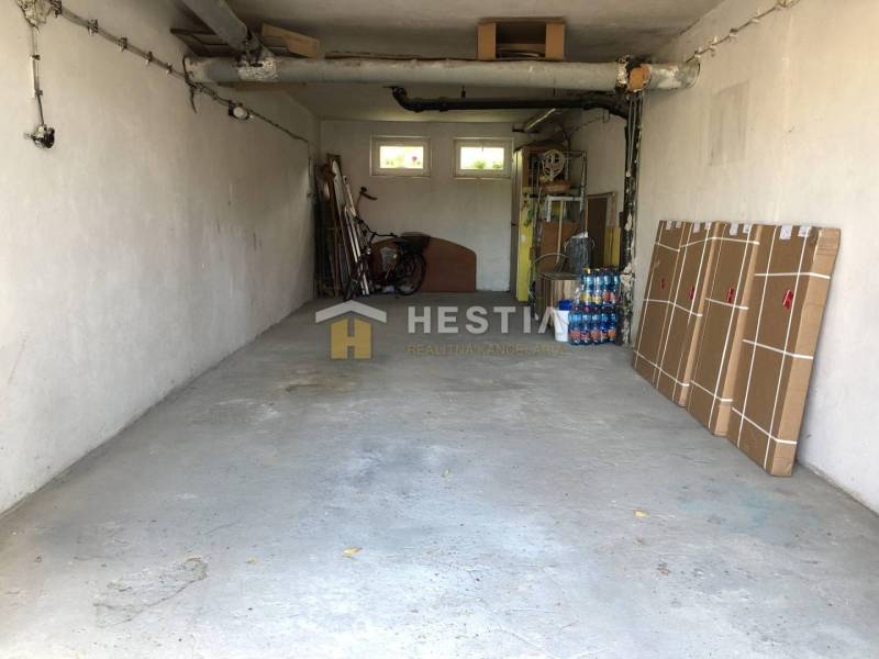 Garáž v 3-pokojovém bytě s odloženými předměty a kolem.