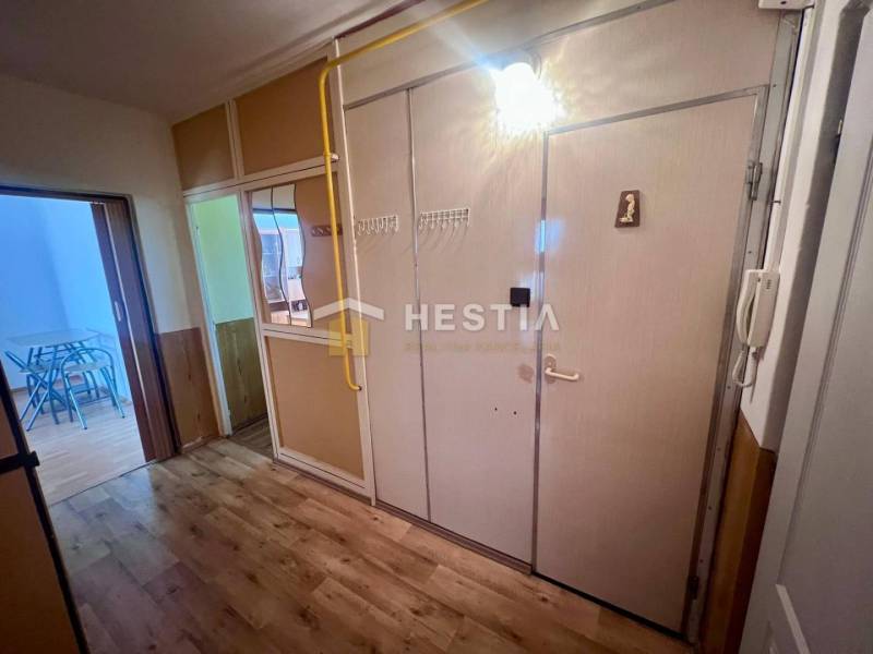 Chodba v 3-pokojovém bytě s věšákem, zrcadlem a interiérovými dveřmi.