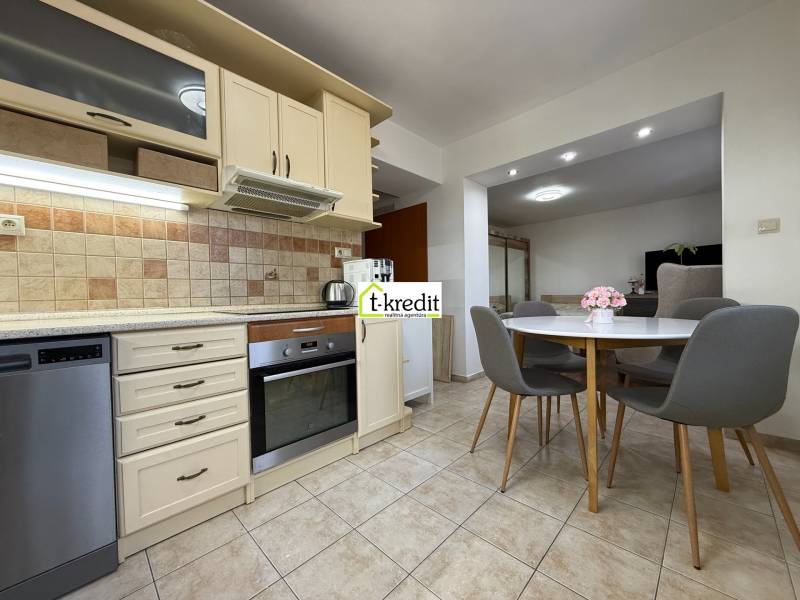 Kuchyně s kuchyňskou linkou a jídelním stolem v 2-pokojovém bytě.