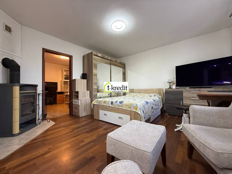 Interiér pokoje s podlahou s dřevěným dekorem a krbem v 2-pokojovém bytě.