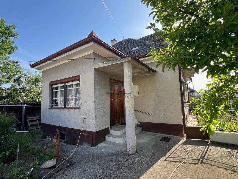 Rodinný dům v Drahovcích na ulici Drahovce se zahradou a úzkou vstupní bránou.