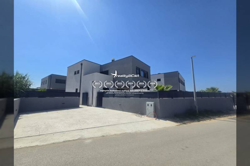 Vila na ulici Zukve ve Vrsi s velkou příjezdovou cestou a jednoduchou fasádou.