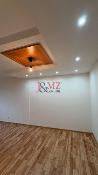 Stropní lampa a podlaha s dřevěným dekorem v 2pokojovém bytě.