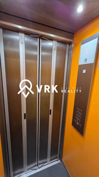 Výtah v budově, s tlačítky a displejem ukazujícím páté patro.