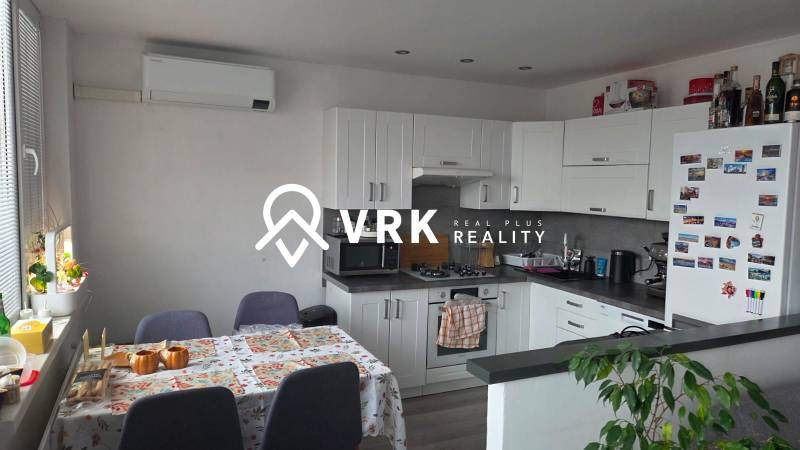 Kuchyně v 3-pokojovém bytě s rohově umístěnou kuchyňskou linkou a klimatizací.