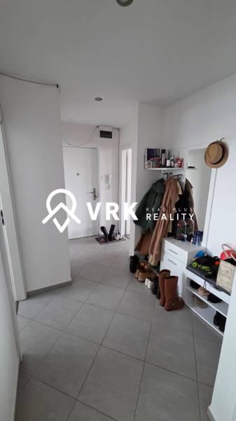 Chodba v 3-pokojovém bytě s dlažbou, botníkem, zrcadlem a věšákem na kabáty.