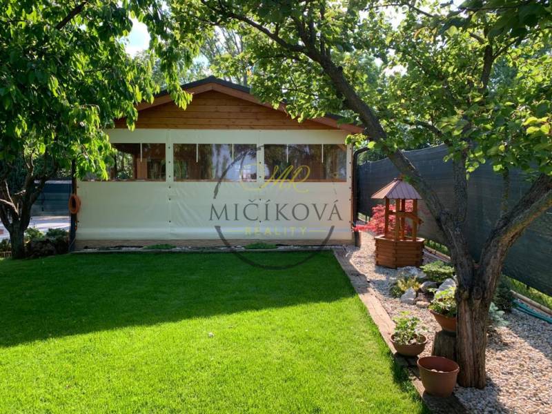 Zahrady v Dolních Krškanech, Nitra, s trávníkem, altánkem a dřevinami.