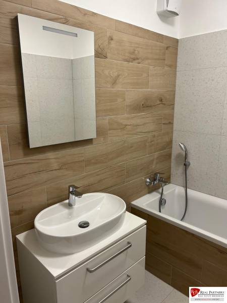 Koupelna v 2-pokojovém bytě s podlahou s dřevěným dekorem a vanou.