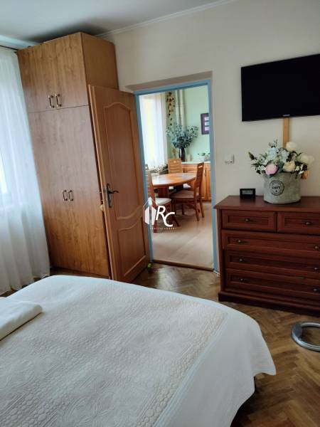 Ložnice s vestavěnou skříní v 2pokojovém bytě, podlaha s dřevěným dekorem, dveře vedou do kuchyně.