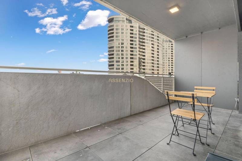 Balkon s moderním nábytkem, výhled na vysoké budovy v Bratislavě - Novém Městě.