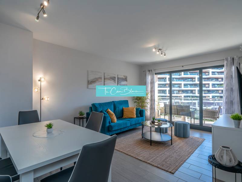 Obývací pokoj v 2pokojovém bytě s podlahou s dřevěným dekorem a posezením.