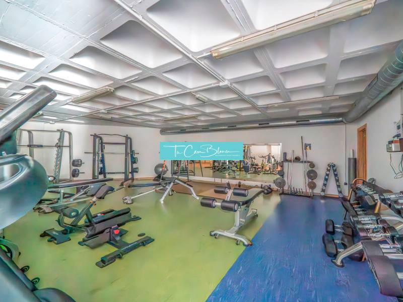 Posilovna se stroji a zrcadlem v 2pokojovém bytě.