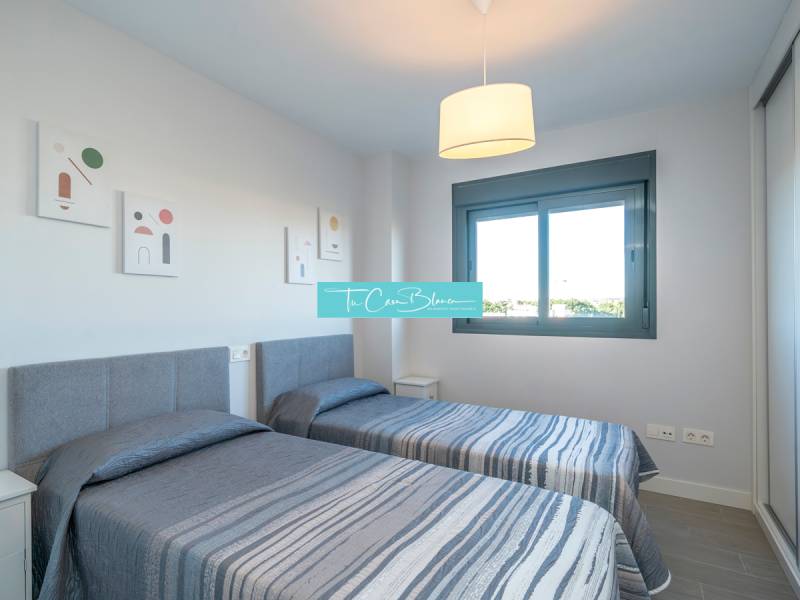 Dvě jednolůžkové postele v 2-pokojovém bytě s oknem a dekorativními obrazy na stěně.