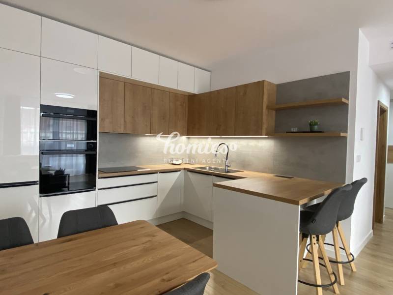 Kuchyně v 2-pokojovém bytě s podlahou s dřevěným dekorem a dřevěnými detaily.