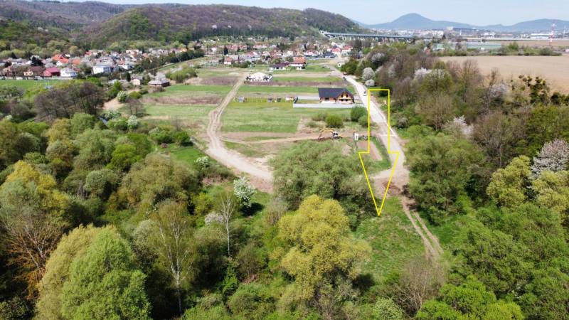 Letecký pohled na pozemky v Hanisce obklopené zelení a dopravní infrastrukturou.