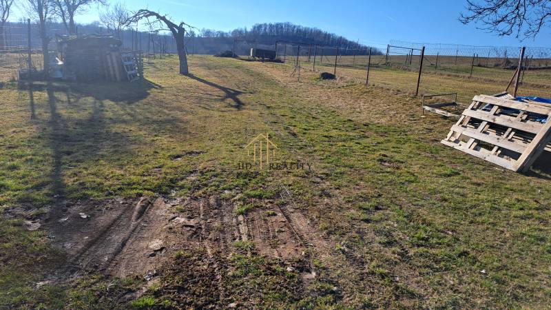 Rozlehlý dvůr s dřevěnými paletami v blízkosti chaty u Kráľovců Krnišova.