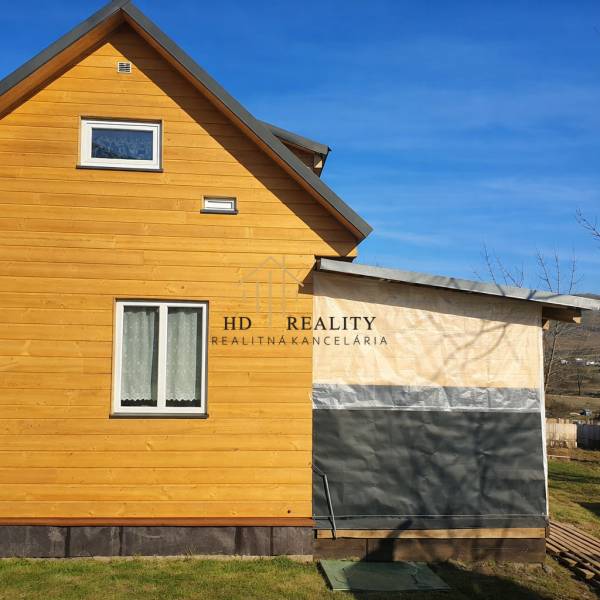 Dřevěná chata v Kráľovcích Krnišově se střechou a plastovými okny.