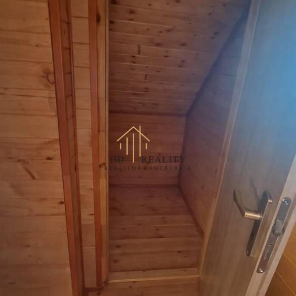 Dřevěný interiér v chatě s dřevěným dekorem a schodištěm.