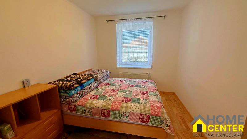 Ložnice v rodinném domě s postelí a podlahou s dřevěným dekorem.