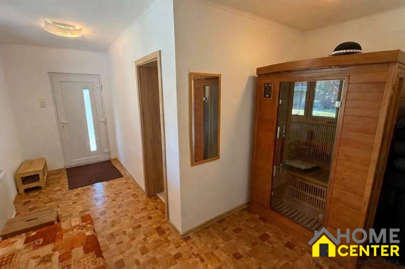 Chodba v rodinném domě s podlahou s dřevěným dekorem a vestavěnou saunou.