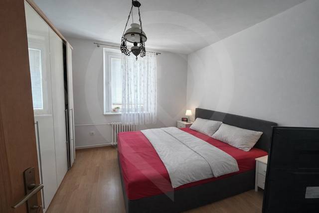 Ložnice s postelí a skříňkou, podlaha s dřevěným dekorem, 3pokojový byt.