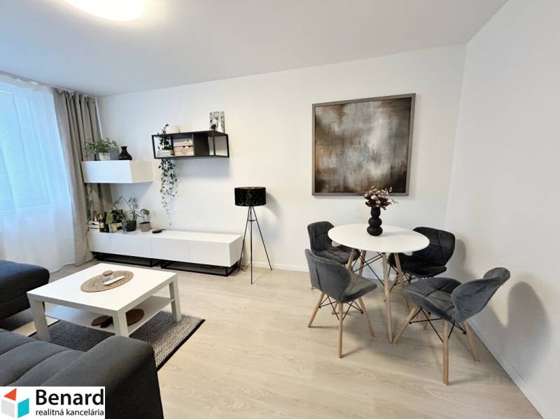 Interiér 2-pokojového bytu se stolem, židlemi a dekoracemi, podlaha s dřevěným dekorem.