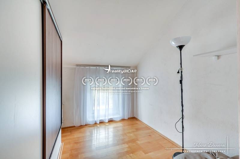 Pokoj v rodinném domě s podlahou s dřevěným dekorem a skříňkou.