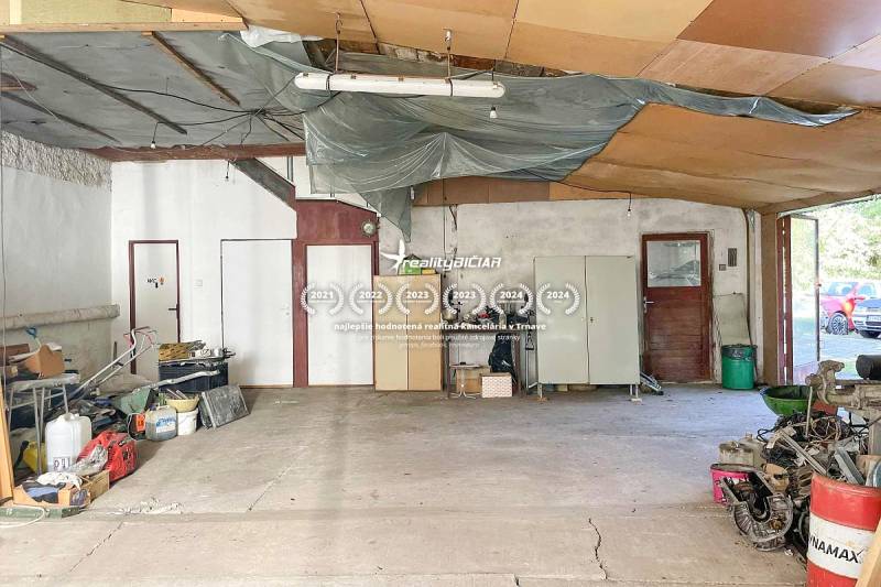 Interiér rodinného domu s rozlehlým prostorem, odloženými věcmi a cementovou podlahou.