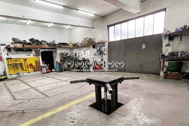 Dílna s nářadím, pracovním stolem a šachtou, bez přítomnosti lidí. Rodinný dům.