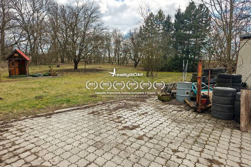 Pavlice, rodinný dům na Pavlicích s dlážděným dvorem, kůlnou a hromadou pneumatik.