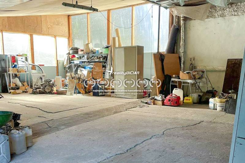 Garáž v rodinném domě plná nástrojů a strojů, s různým vybavením na policích.